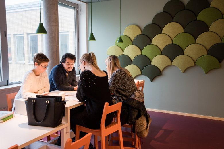 Four persons at a table are talking