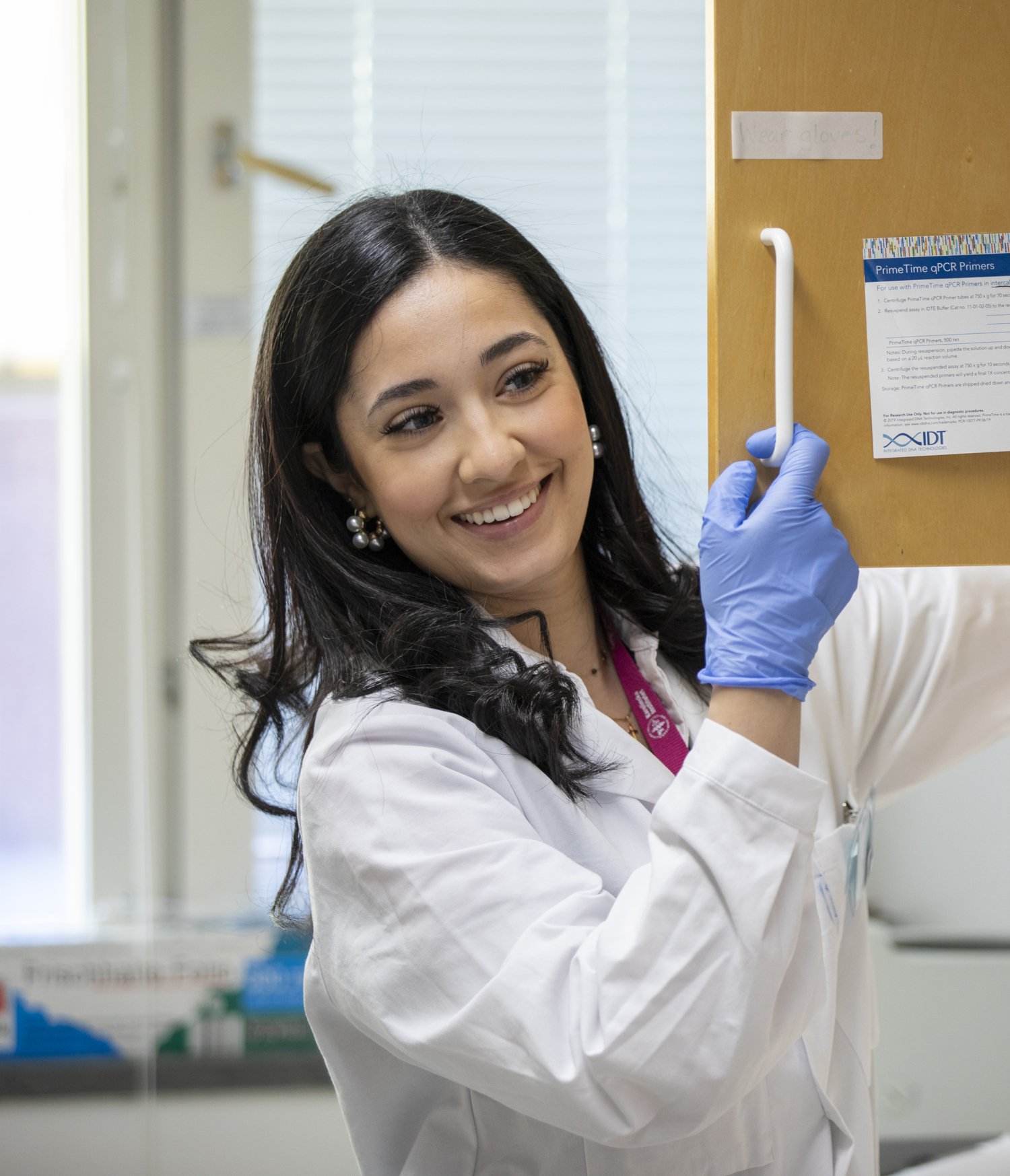 Woman in lab smiling and talking to another researcher.