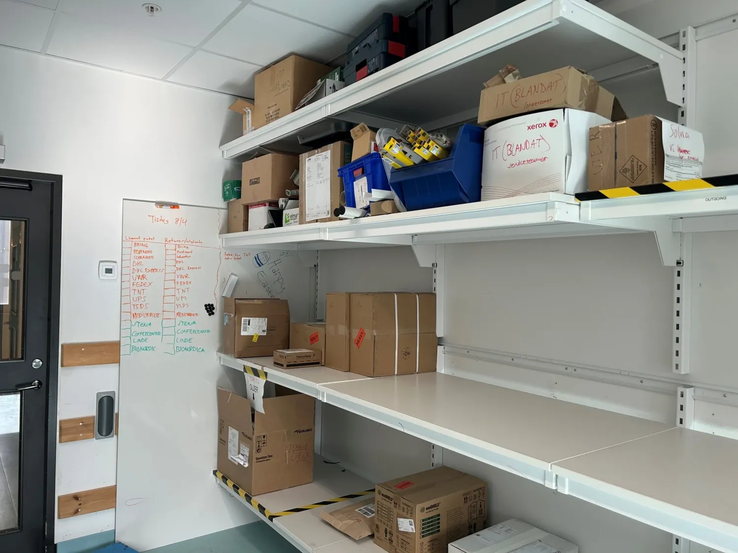 Photo of goods receiving office with with shelves of packages.