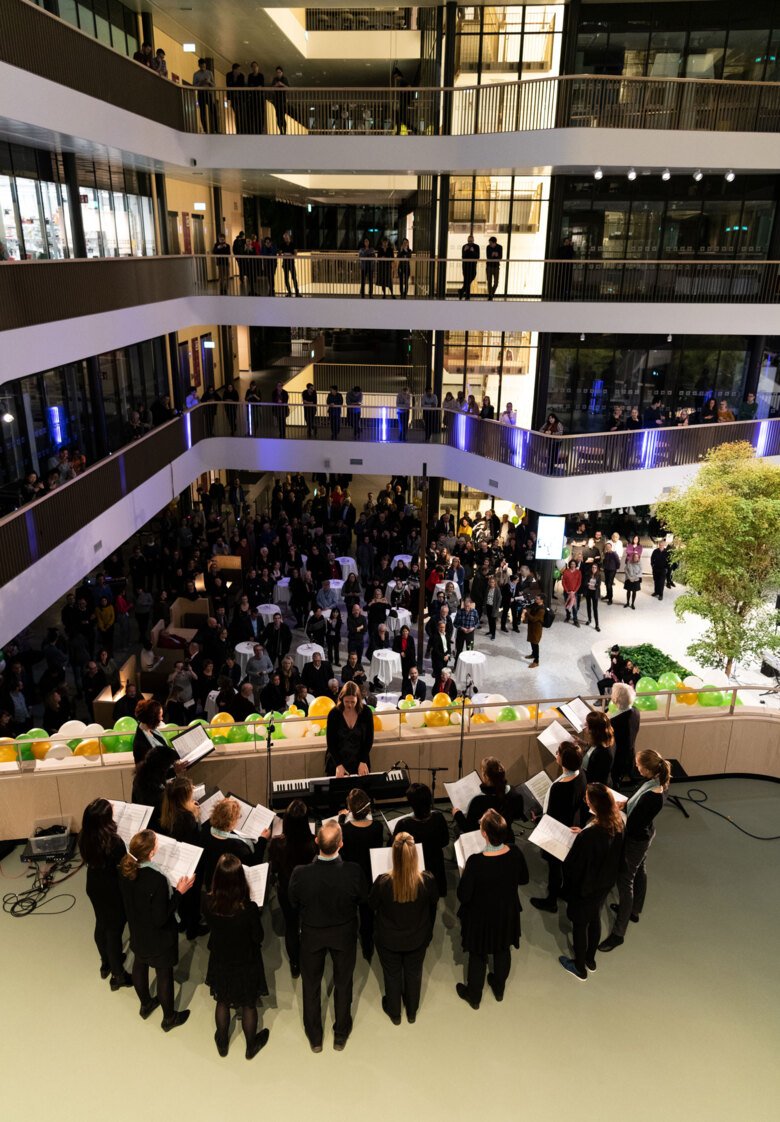 choir performing in the atrium of Biomedicum at the inauguration. Audience is spread out on different levels of the building.