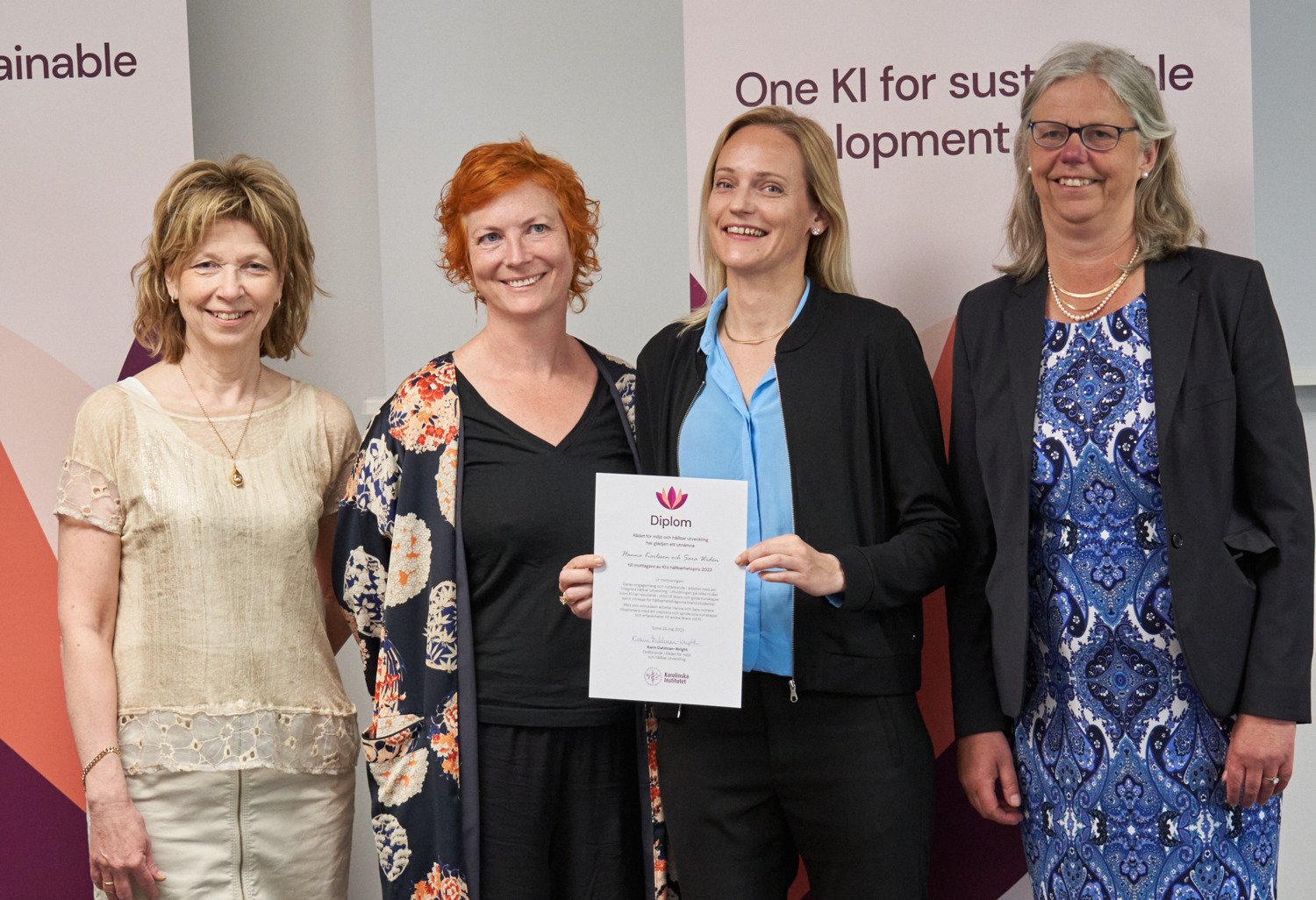 Hanna Karlsson and Sara Widén hold up their diploma, flanked by KI's president Annika Östman Wernersson and Karin Dahlman-Wright, chair of the Council for the Environment and Sustainable Development.