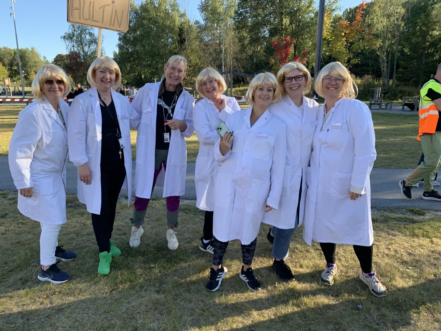 Team Hultin is dressed in white lab coats and the same blonde wig