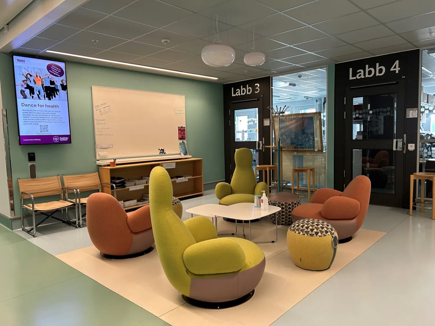 Photo of lounge area with colorful furniture and a table.