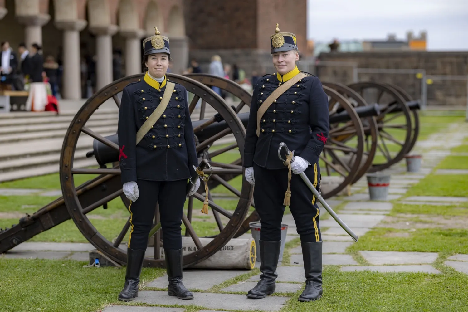Two people in festive costumes are waiting to fire a salute.
