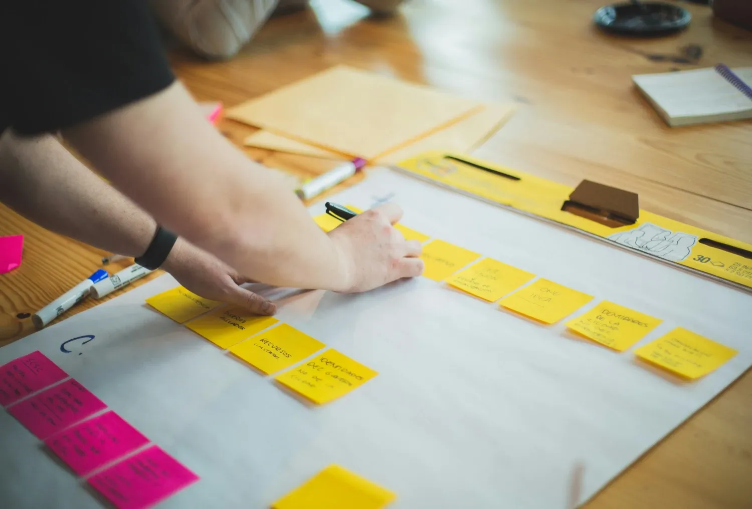 Person writing at sticky notes.