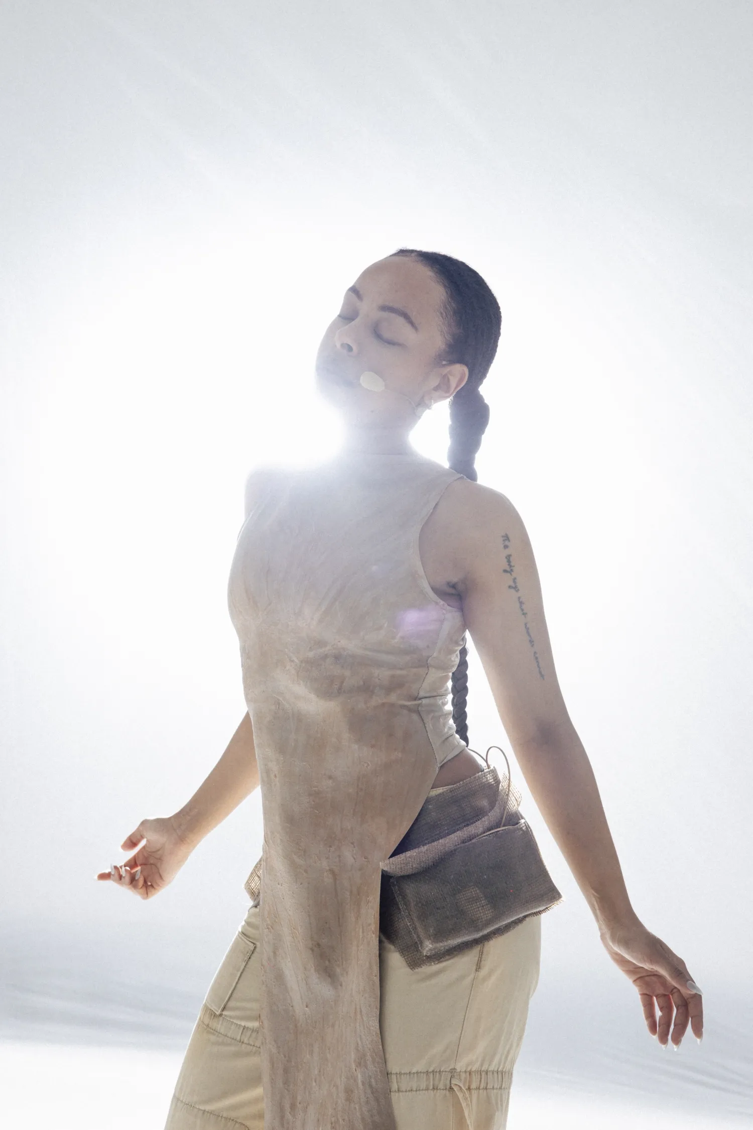 Woman i beige clothes reaching out her arms and looking up.