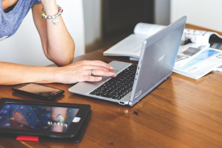 Hands of a woman writing on a laptop.