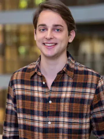 Young man with blue eye in a flannel shirt.