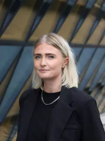 Bild på Evelina Flodkvist, en kvinna med blont hår och svart kavaj