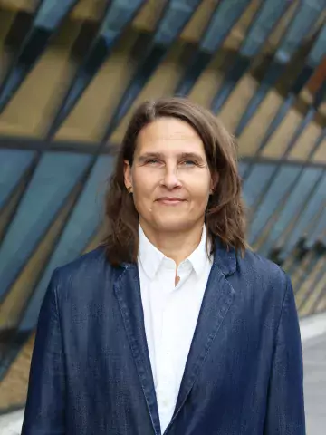 Bild på Lisa Strömmer, kvinna med mörkt hår, blå kavaj och vit skjorta
