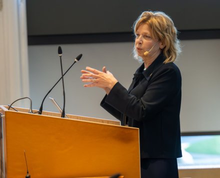 President Annika Östman Wernerson at the podium in a spacious hall at Biomedicum