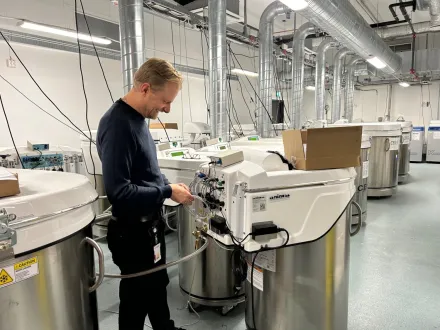 A male technician stands by a new freezer to be installed in ANA Futura's freezer facility.